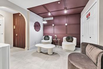 a living room with couches and chairs and a door at The Meriden, 06450